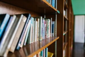 A wooden bookshelf filled with books in a cozy library setting, perfect for educational themes.
